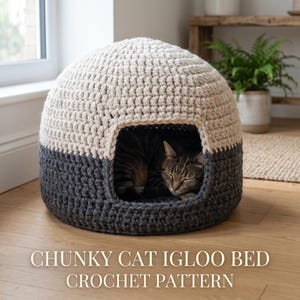 May include: A two-tone, chunky crochet cat igloo bed in cream and charcoal gray. The cat bed has a rounded shape with an opening, and a tabby cat is sleeping inside. The text "CHUNKY CAT IGLOO BED CROCHET PATTERN" is at the bottom.