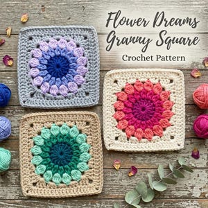 Könnte beinhalten: Drei quadratische Häkelmotive mit einem zentralen Blumenmuster und strukturierten Blütenblättern. Ein Quadrat ist grau mit Blau und Lavendel, eines cremefarben mit Pink und Magenta, eines beige mit Petrol und Grün. Text: Flower Dreams Granny Square.