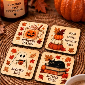 Pode incluir: Quatro porta-copos quadrados de madeira com ilustrações de outono. Um mostra uma caneca de abóbora com PUMPKIN SEASON, outro abóboras com GOOD COFFEE BRIGHTER DAYS, um fantasma com SPOOKY SIPS e um gato preto com AUTUMN VIBES.
