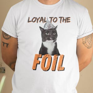 Maglietta unisex con gatto e cappello di carta stagnola: divertente teoria del complotto immagine 1