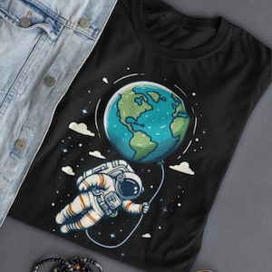 Camiseta de astronauta con globo terráqueo, camiseta de aventura espacial, camiseta minimalista con arte espacial, regalo de dibujos animados cósmicos para él o ella, colores cómodos