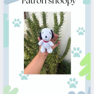 May include: A white and black crocheted Snoopy doll with a red collar. The image includes the text "Patrón snoopy" and "Patrón creado por jennyavilacrochet" on a light blue background with paw prints.