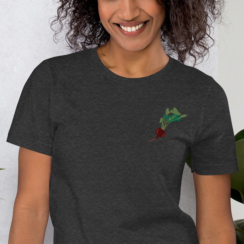 May include: A dark heather grey t-shirt with a small embroidered image of a red beet with green leaves.