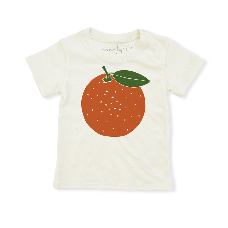 May include: A white t-shirt with a green leaf and orange fruit graphic. The text "twenty-five" is printed on the shirt.