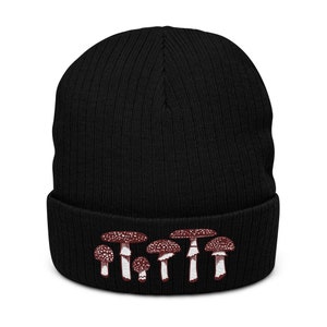 May include: Black knit beanie with a white and red embroidered design of mushrooms.