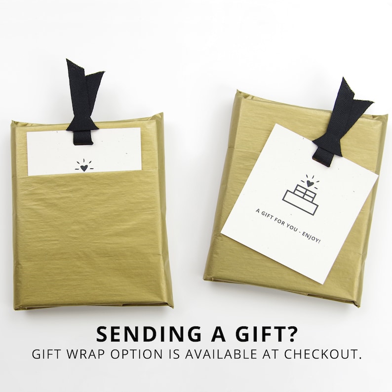 May include: Two gold gift boxes with black ribbon bows and white gift tags. The tag on the left box has a heart icon. The tag on the right box has a cake icon and the text "A gift for you - Enjoy!"