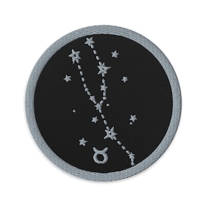 May include: A black and silver embroidered patch with the Taurus constellation and the Taurus zodiac symbol.