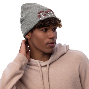 May include: A gray beanie with a red mushroom graphic and the text "Shroom Queens".