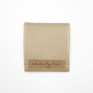 May include: A brown paper package with a label that says "eleventy-five" in cursive.
