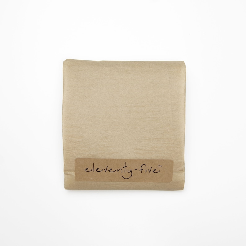 May include: A brown paper package with a label that says "eleventy-five" in cursive.