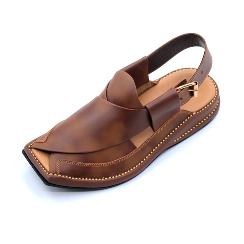 May include: Brown leather sandals with a strap and buckle. The sandals have a pointed toe and a decorative stitch around the edge.