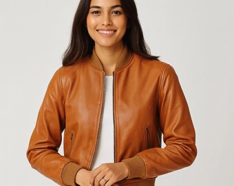 May include: A brown leather bomber jacket with a zip-up front, ribbed cuffs, and a ribbed hem. The jacket has a classic bomber style with a collar and two side pockets. The jacket is a warm brown color.