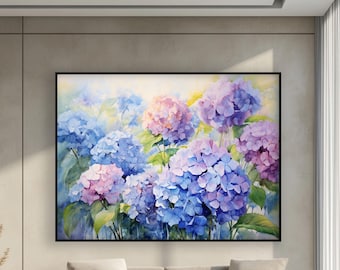 May include: A large framed watercolor painting of hydrangeas in shades of blue, purple, and pink. The flowers are in full bloom with green leaves. The painting is displayed above a beige sofa in a modern living room.