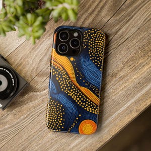 May include: A blue and orange phone case with a geometric pattern. The case has a raised camera bump with three lenses.