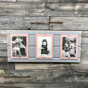 May include: Three black and white photographs of children are displayed in a gray and pink picture frame with a woodgrain background. The frame has three separate compartments for each photo.