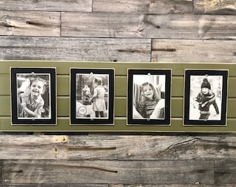 May include: Four black framed photos of children, each with a different image, are displayed on a green wooden plank. The photos are arranged horizontally.