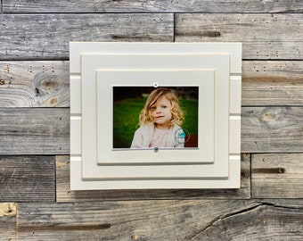 Distressed white wood picture frame holds a 5x7 photo
