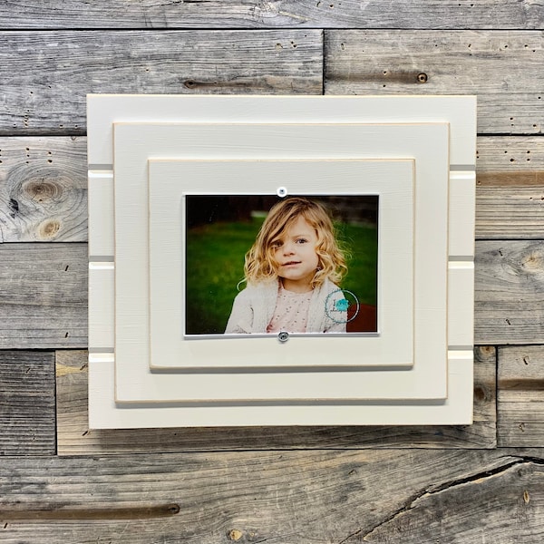 Distressed white wood picture frame holds a 5x7 photo