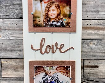 May include: White wooden picture frame with two openings for photos. The frame has a copper colored border and the word "love" is written in copper colored script. The top photo shows a young girl smiling. The bottom photo shows two children hugging on a bridge.
