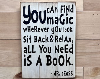 May include: A white wooden sign with black lettering that reads "You can find magic wherever you look. Sit back & relax, all you need is a book. - Dr. Seuss."