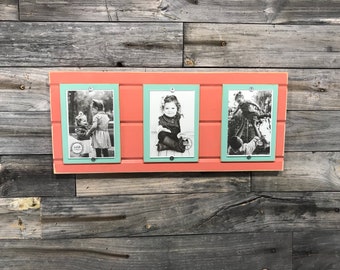 May include: Three framed black and white photos of children on a coral colored wooden background. The frames are light blue with a white border.