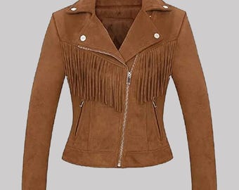 May include: A brown suede jacket with a zipper closure and fringe detailing across the chest. The jacket has a notched collar, two front pockets, and silver-tone buttons. The jacket is a stylish outerwear piece.