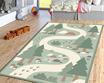 Op de afbeelding: Een rechthoekig vloerkleed met een grillig bosontwerp. Het kleed heeft een kronkelend pad, bomen, paddenstoelen en dierensporen in groen, beige en bruin. Het kleed heeft een groene rand en is geschikt voor een kinderkamer.
