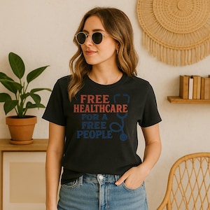 May include: Black t-shirt with the text "FREE HEALTHCARE FOR A FREE PEOPLE" in red and blue. The design includes a stethoscope graphic. The shirt is worn by a person wearing sunglasses and blue jeans.