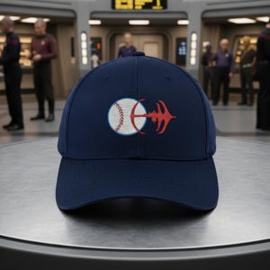 May include: Navy blue baseball cap featuring an embroidered design of a baseball and a red emblem. The cap has a curved brim and a structured crown. The design is on the front of the cap.