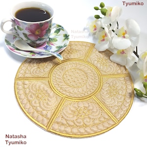 以下が含まれることがあります： 金色に刺繍されたデザインが施された、丸いベージュのコースター。コースターは6つのセクションに分かれており、それぞれ異なるパターンになっています。コースターは白い表面の上に置かれています。