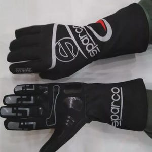 May include: Pair of black Sparco racing gloves. The gloves have a white and silver Sparco logo on the back of the hand and the wrist. The palm of the glove has a textured grip. The gloves are designed for motorsports.