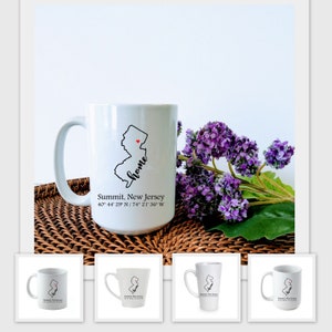 May include: White ceramic mug with a black outline of the state of New Jersey and the word "home" written in cursive. The state has a small red heart in the center. The mug also has the text "Summit, New Jersey 40° 44' 29" N/74° 21' 36" W" printed on the bottom.