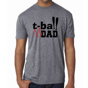 May include: A heather grey t-shirt with black text that reads "t-ball DAD" and a red baseball graphic.