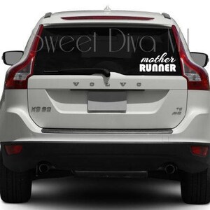 May include: White car with a black rear window and a white vinyl decal that says "mother runner" on the back.