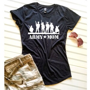 K&ouml;nnte beinhalten: Schwarzes T-Shirt mit einer wei&szlig;en Silhouette von Soldaten und dem Aufdruck "ARMY MOM" auf der Vorderseite.
