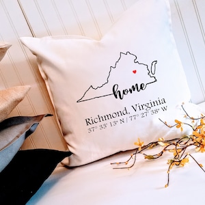 May include: White throw pillow with a black outline of the state of Virginia and the word "home" written in cursive. The pillow also includes the text "Richmond, Virginia 37° 33' 13" N / 77° 27' 38" W".