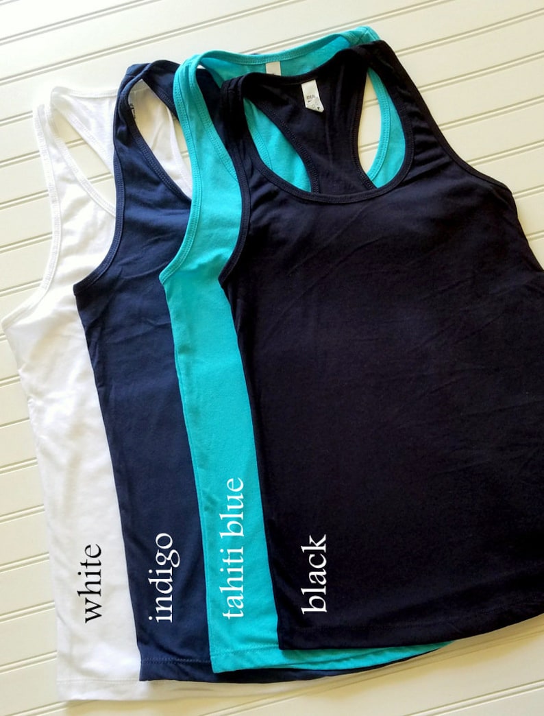 May include: Three racerback tank tops in white, indigo blue, and black. The tank tops are layered on top of each other, with the white tank top on the bottom and the black tank top on the top. The tank tops are all made of a soft, comfortable fabric.