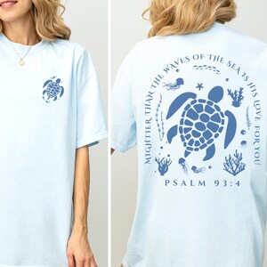 a woman wearing a blue shirt with a turtle on it