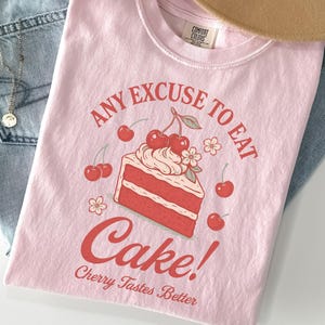 a pink shirt with an image of a cake on it