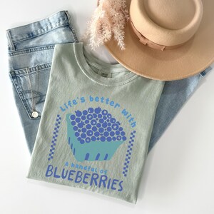 a hat, jeans, and a t - shirt on a white surface