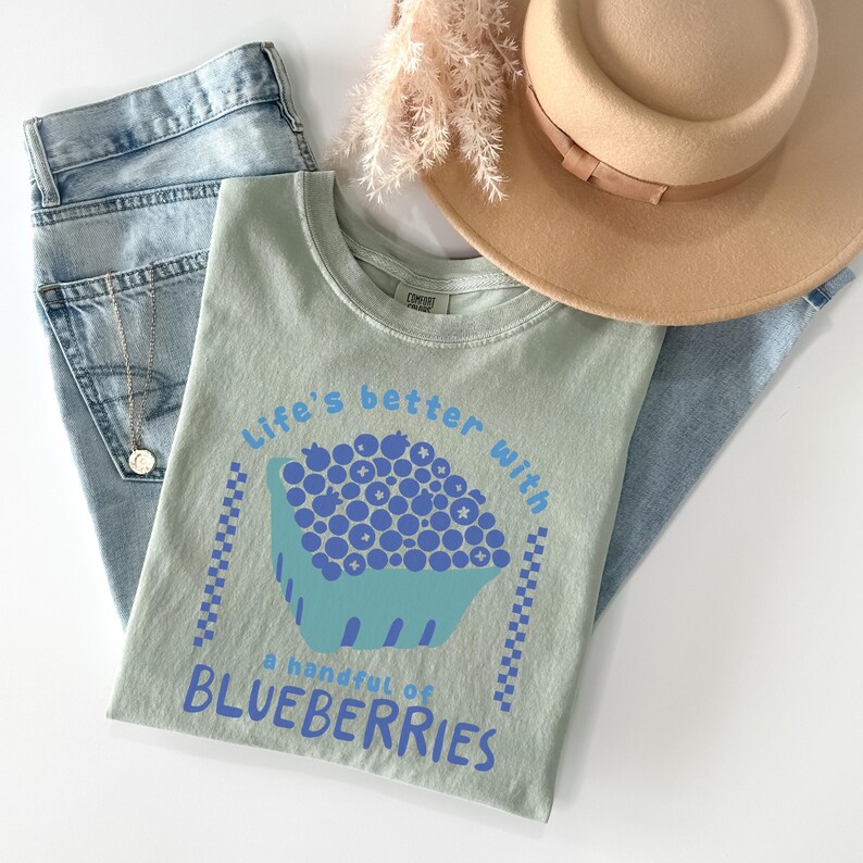 a hat, jeans, and a t - shirt on a white surface