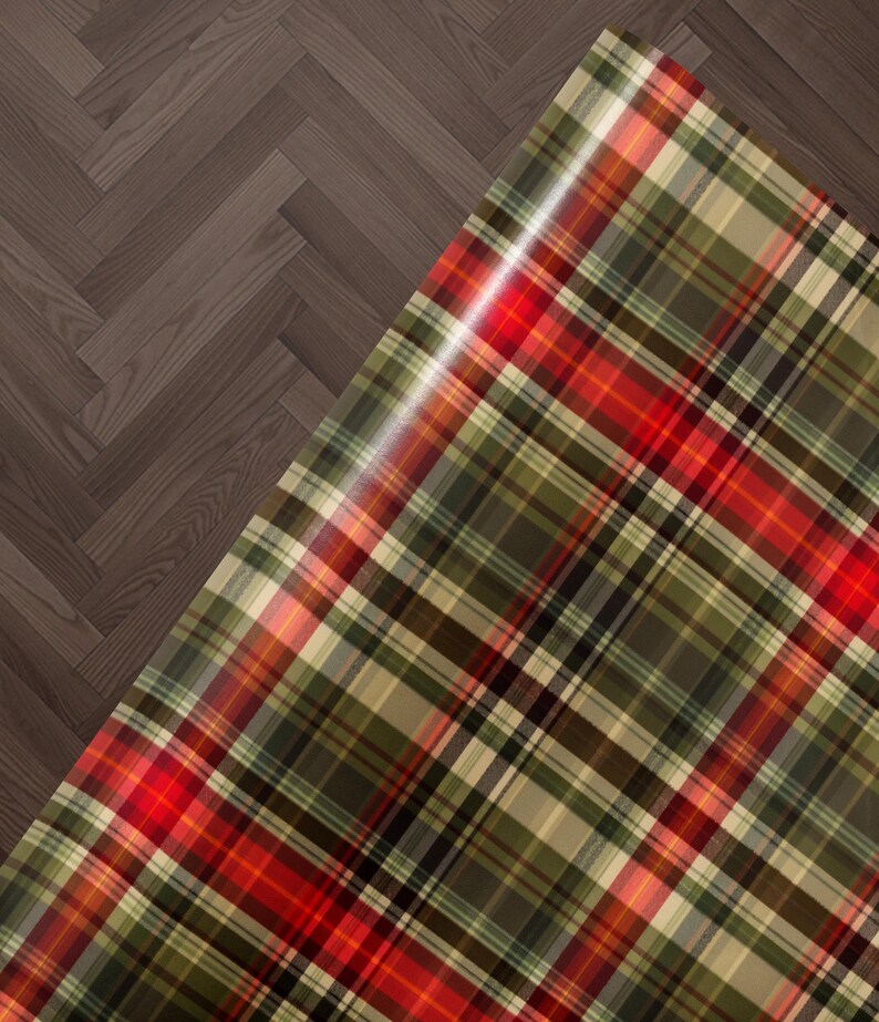 a close-up view of a plaid fabric with a wooden floor in the background.