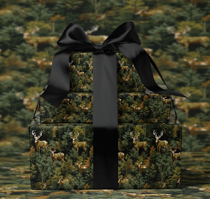 A gift box with a black ribbon tied around it, featuring a forest-themed design with deer and trees.