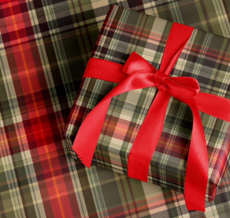 A gift box wrapped in a plaid pattern with a red ribbon tied around it.