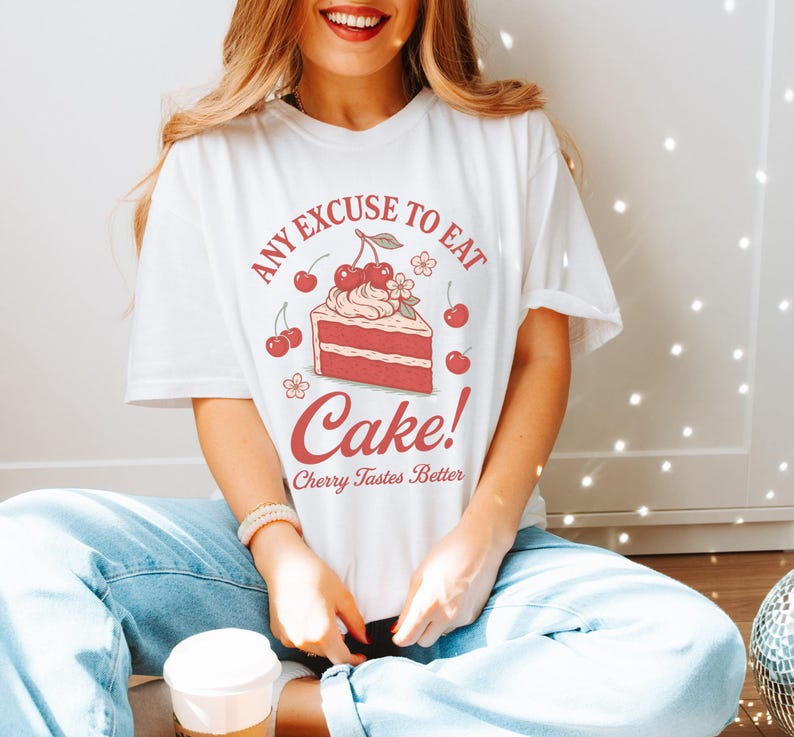a woman sitting on the floor with a cake on her shirt