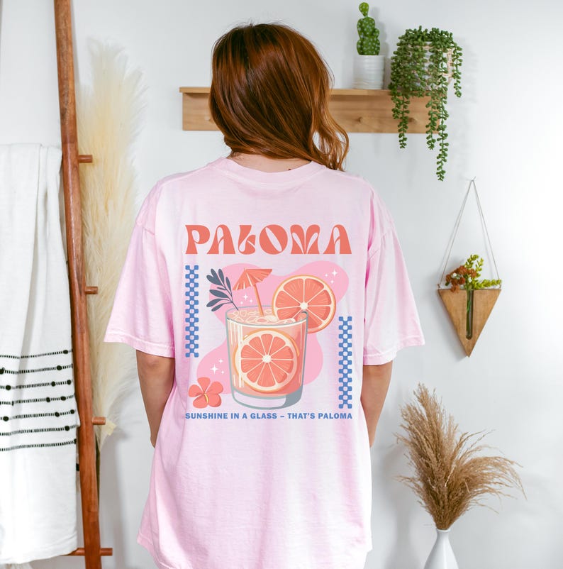 a woman in a pink shirt standing in front of a wall