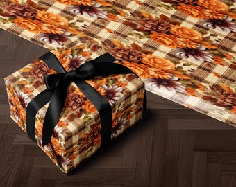 Op de afbeelding: Een ingepakte geschenkdoos met een zwarte satijnen strik. De doos en het inpakpapier hebben een bloemenpatroon met oranje, bruine en crèmekleurige bloemen op een geruite achtergrond. Het cadeau ligt op een donkere houten ondergrond.