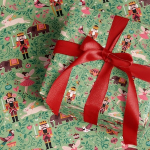 Puede incluir: Un montón de regalos envueltos con papel de regalo verde con un patrón de cascanueces, hadas, elefantes y conejos. Los regalos están atados con una cinta y un lazo de satén rojo brillante. Perfecto para regalos de Navidad o cumpleaños.