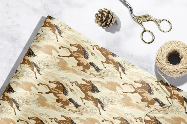a beige and brown patterned wrapping paper with a horse design, along with a pair of scissors, a pine cone, and some string or twine.