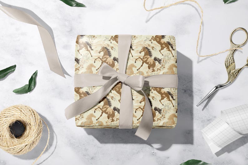 a gift box with a horse patterned wrapping paper, a ribbon, and some crafting supplies such as scissors and twine.